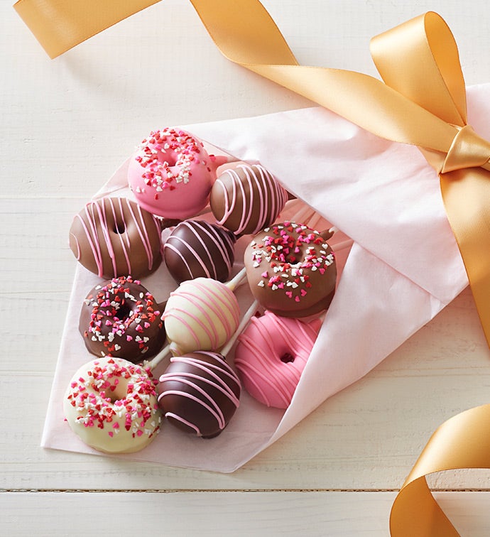 Pink and orange birthday cake decorated with macaroons, meringues, donuts,  waffle cones, cake pops and chocolate bars Stock Photo - Alamy